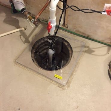Central component of a radon mitigation system in a basement installed by Green Earth Remediation.
