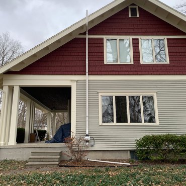 Discreet radon mitigation setup by Green Earth Remediation next to a white entrance door.