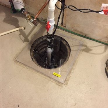 Detailed setup of a radon mitigation system in a residential basement by Green Earth Remediation.