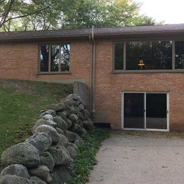 Radon mitigation pipe installation along the house foundation by Green Earth Remediation, enhancing home safety.