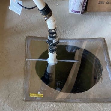 Technician from Green Earth Remediation sealing the entry point for a radon mitigation system in a residential setting.