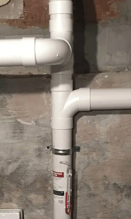 White pipe in interior section of commercial radon mitigation system.